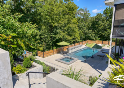hardscaping and green landscaping with a fiberglass pool and spa in the background